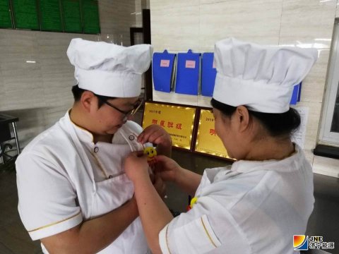 安居煤矿食堂职工佩戴“笑脸牌”上岗